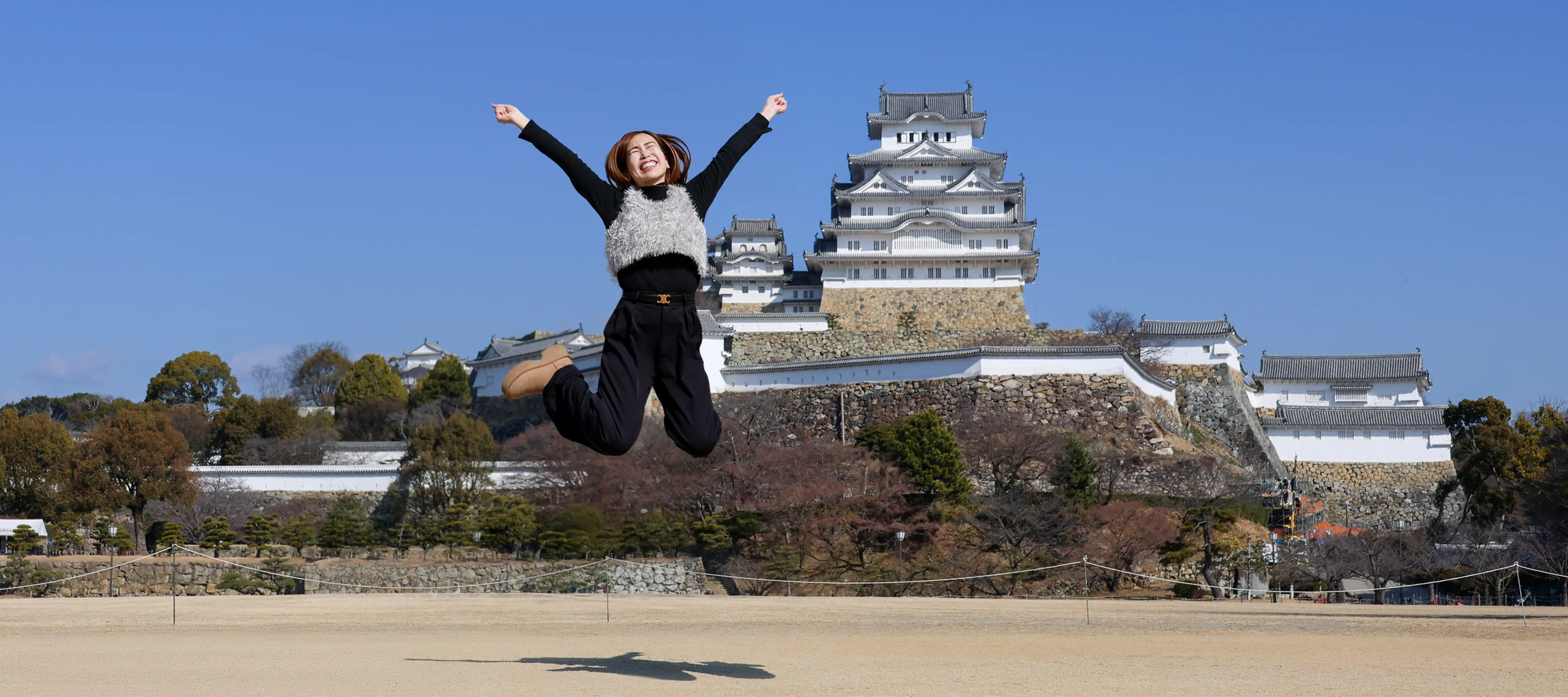 姫路城の前でジャンプする女性